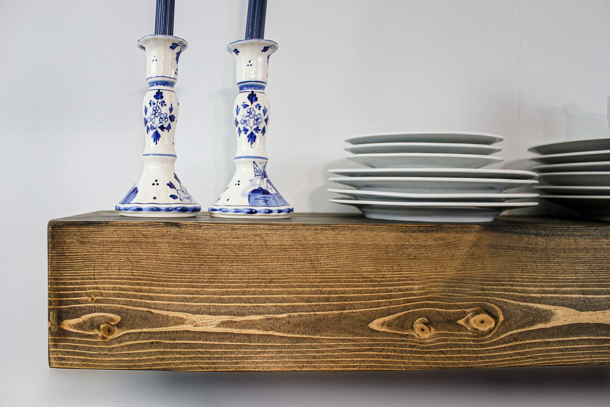 closeup of floating wooden beam shelf solid pine wood that is locally sourced from Alabama and hand cut, built into a hollow box form, and stained by the artist Abdul Nasser. The hollow design keeps the overall piece light weight and slides over a dental insert that is mounted to the wall studs for super sturdy hold for shelves or a mantelpiece on your fireplace. The old world vintage decor with the timber beam in place of outdated cabinetry in your kitchen or dining room