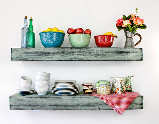 vintage 1940s kitchen shelves distressed paint in green over black on thick beam size shelves, the paint has a rustic worn vibe for an authentic aged used look is perfect for a farmhouse kitchen or laundry room, the thick shelf can also be used as a mantel piece over a fireplace. Makes a great housewarming gift for people who love vintage home decor or farmhouse interior design, has a Southern country old world look perfect in a country store or restaurant