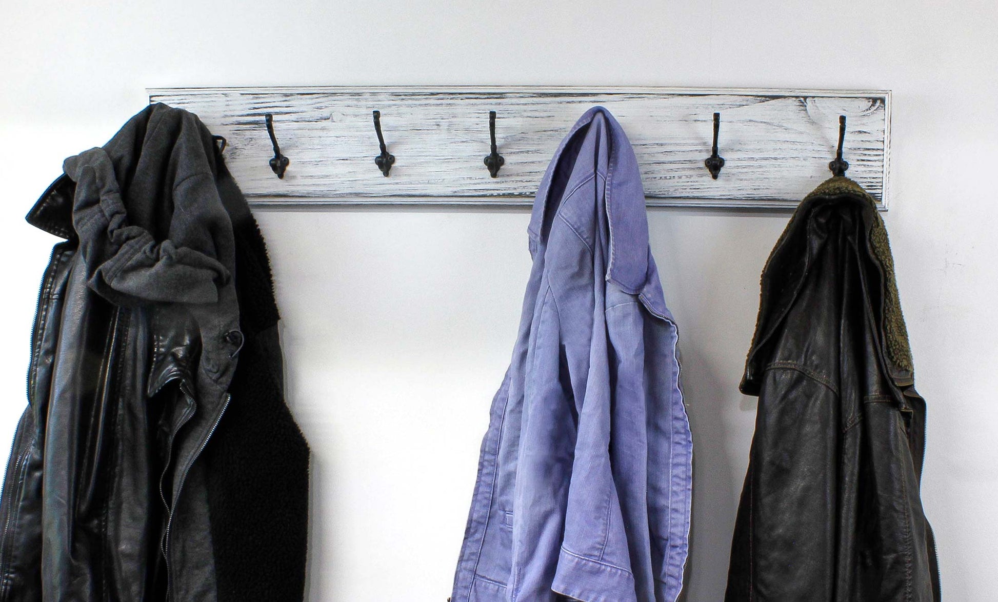 Rustic wood coat rack with labeled features: heavy-duty hooks, locally sourced wood, keyhole mounts. Wall-mounted farmhouse organizer perfect for entryways, bathrooms, or mudrooms. French country or English cottage warm vibes are lovely in a nursery, laundry room, rustic bathroom, or a farmhouse bedroom. It adds a touch of romantic natural charm. The paint layers can be customized with little or a lot of distressing because each rack is made to order. We can even paint the metal hooks.