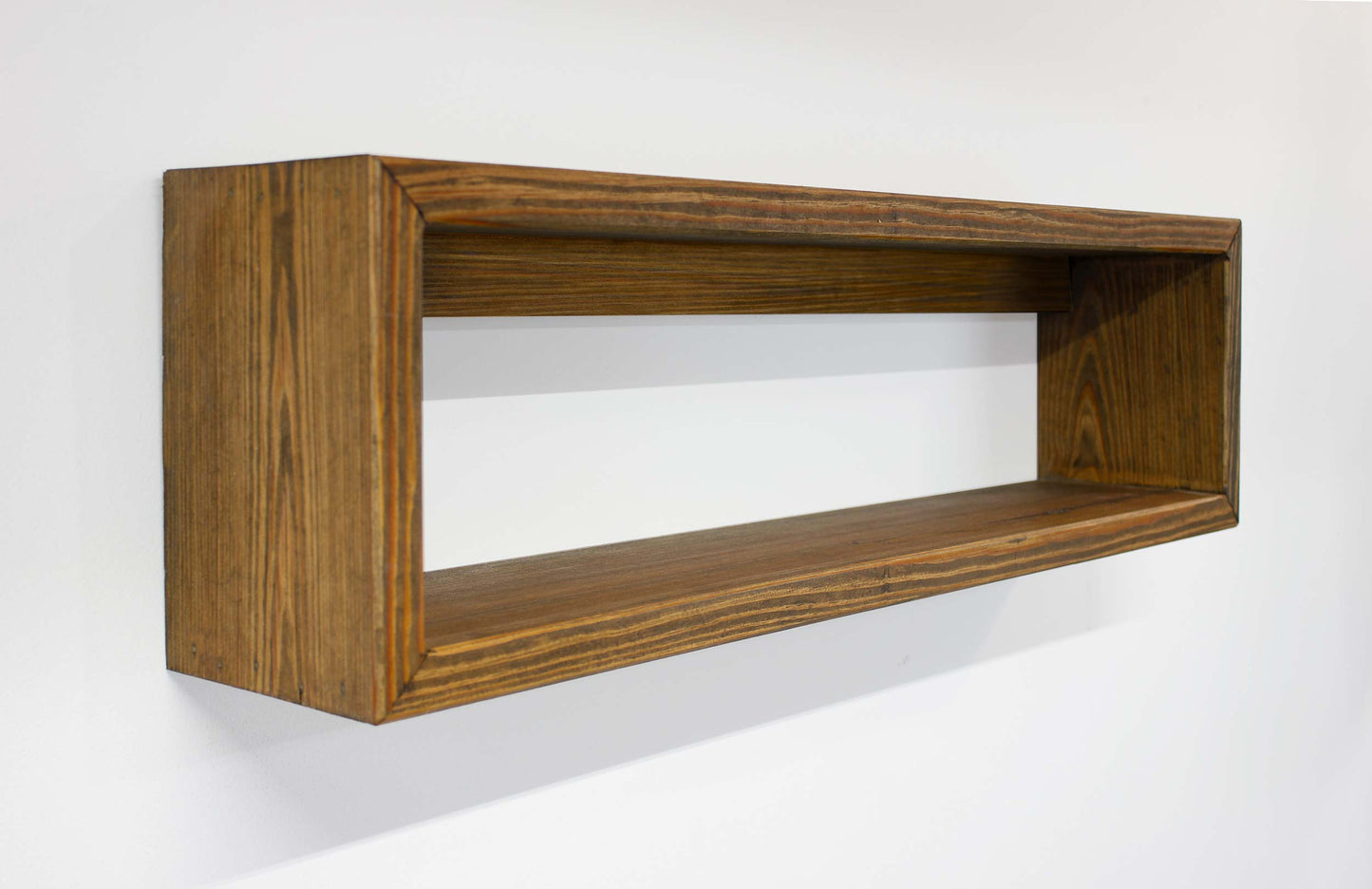 Wooden shelf mounted on a white wall