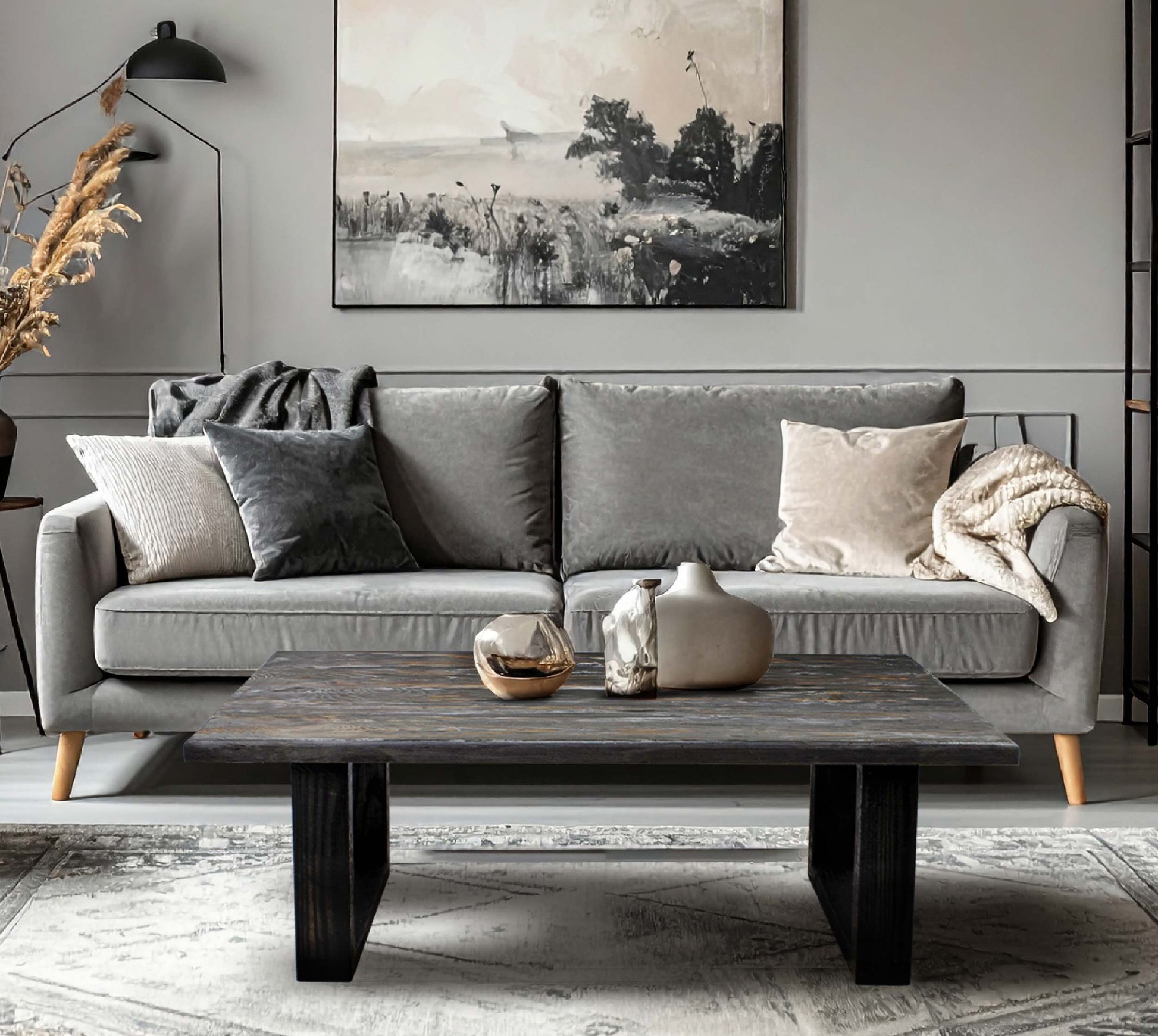 Gray sofa with decorative pillows and a wooden coffee table in a living room setting.