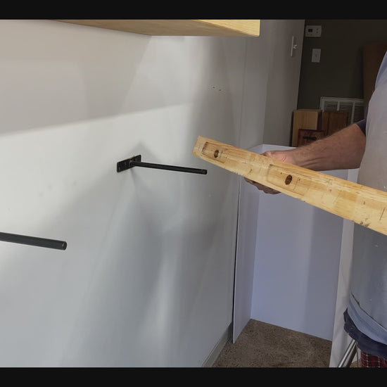video of how the floating shelves are hung on the brackets - see the back of the shelf with the recessed holes for a perfectly flush wall mount