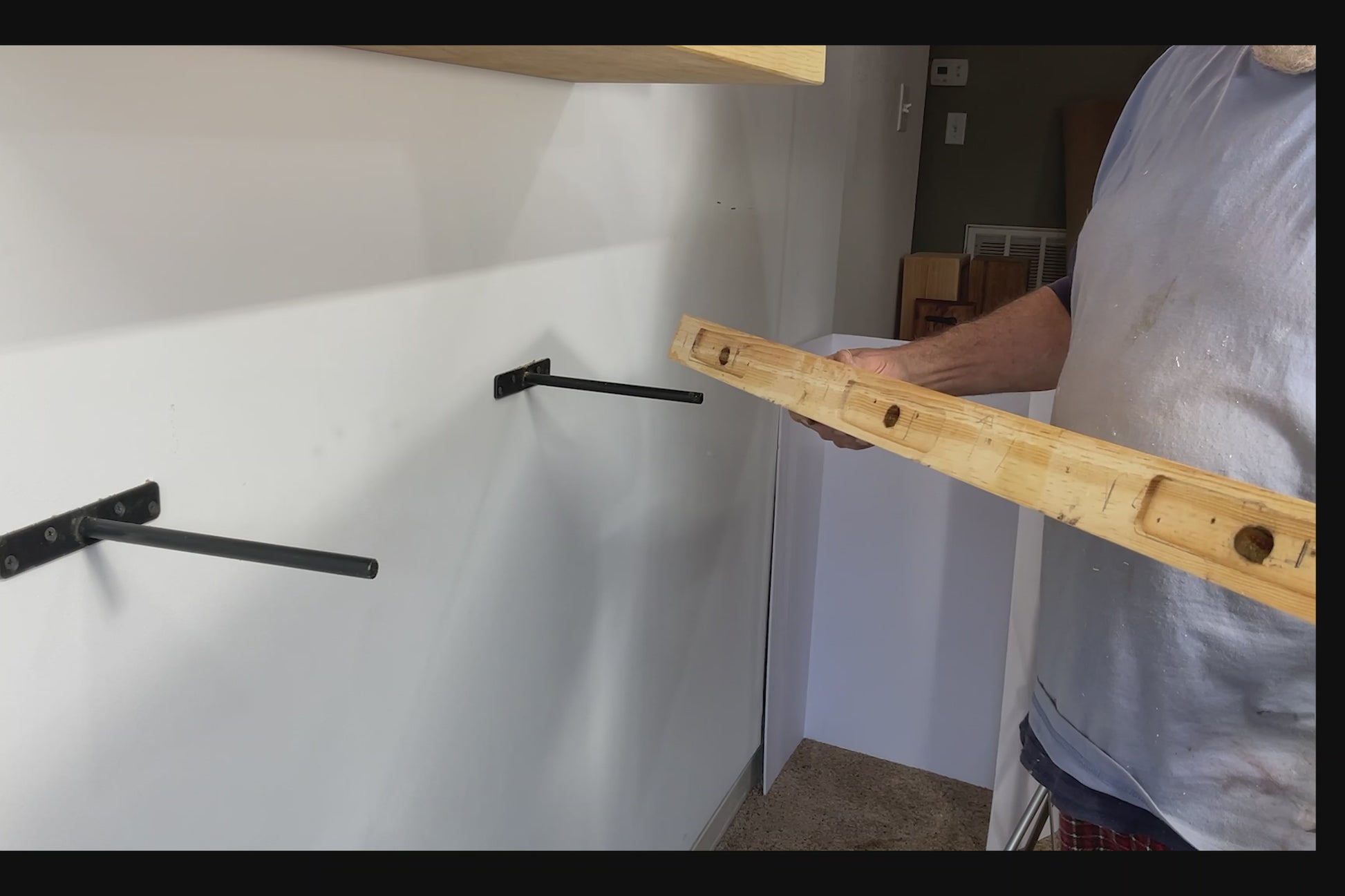 video of how the floating shelves are hung on the brackets - see the back of the shelf with the recessed holes for a perfectly flush wall mount