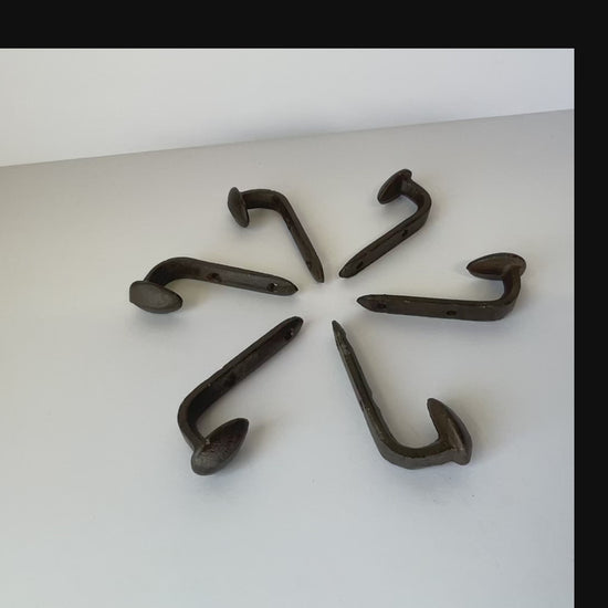 vidoe of a circle of railroad spike cast iron hooks so you can see all of the different angles and the 2 screw holes for mounting