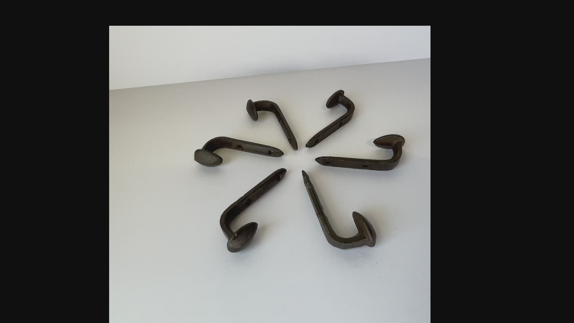 vidoe of a circle of railroad spike cast iron hooks so you can see all of the different angles and the 2 screw holes for mounting