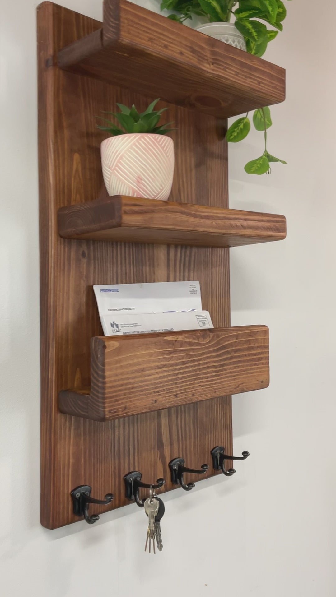 After checking your mailbox you can leave your mail in the holder until you are ready to sort it. The two shelves conveniently hold sunglasses, home decor, holiday decor, welcome signs, pictures, postcards, small plants, or air fresheners to keep your entryway or mudroom neat, tidy and cheerful. You won't forget your things as you leave your home or office. Four small metal double hooks in a row along the bottom of the wooden mail holder to hang keys or dog leashes on for convenient storage. 
