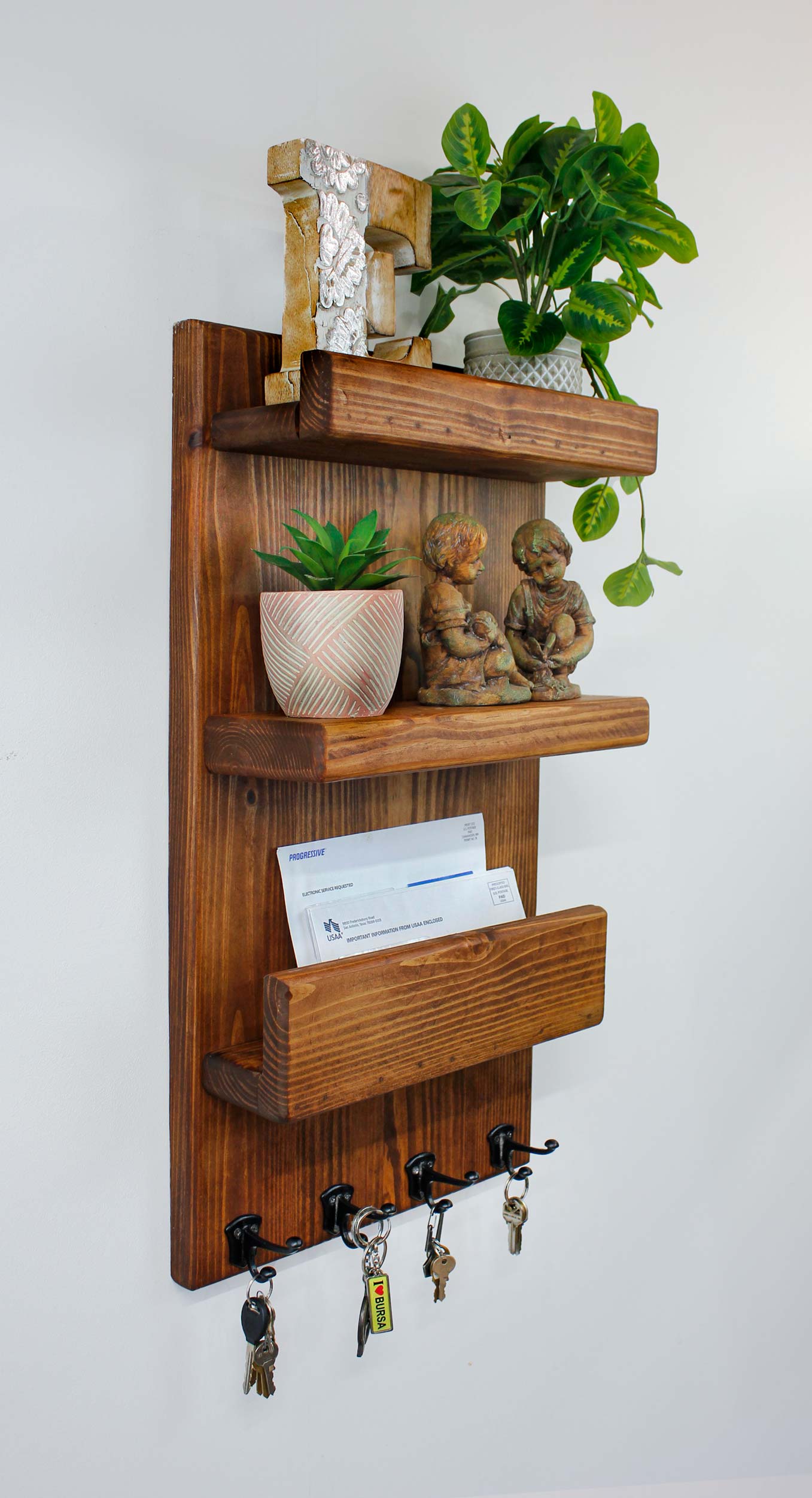 Express yourself by decoring your wood mail organizer and key holder with holiday decor, memorabilia, or cheerful welcoming items as people enter your home or office. The line of four double metal hooks will hold small items like keys, lanyards, IDs, dog leashes, or anything with a handle or strap. The rustic stained solid pine wood gives a country farmhouse vibe which is warm, friendly and inviting to the space. The long narrow design fits well in small versatile and functional space.